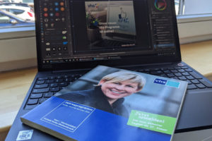 Laptop und altes, gedrucktes Programmheft