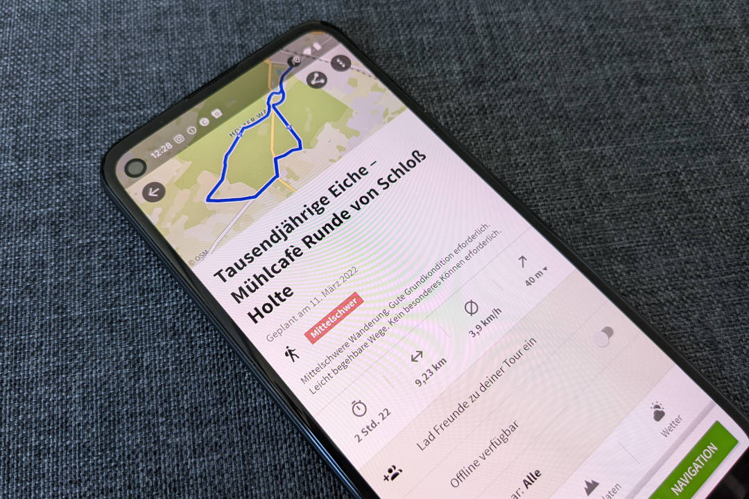 Ein Smartphone zeigt die geöffnete App "Komoot", zu sehen ist eine Karte mit iener eingezeichneten Route.
